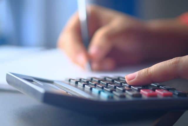 Mains utilisant une calculatrice pour le calcul d'un regroupement de crédits